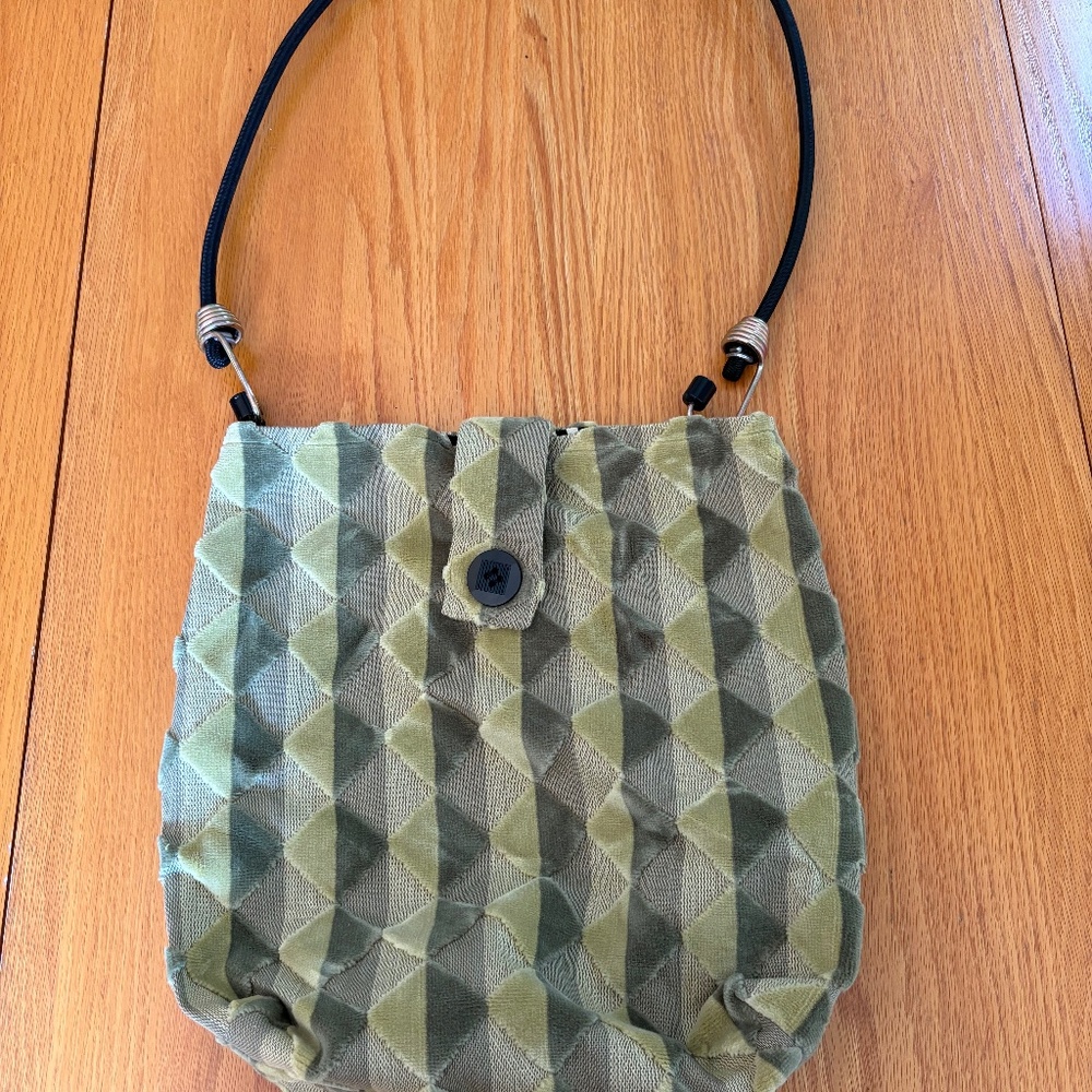 Green bag with diamond and stripe pattern, handmade with a cord handle.